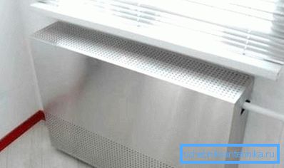 Ecran metalic pe un radiator cu găuri pentru circulația liberă a aerului Ecran metalic pe un radiator cu găuri pentru circulația liberă a aerului