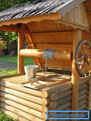 În fotografie - un puț cu o trapă sub un baldachin În fotografie - un puț cu o trapă sub un baldachin