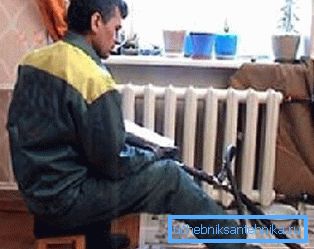 În fotografie, instalatorul spală radiatoarele din apartament În fotografie, instalatorul spală radiatoarele din apartament