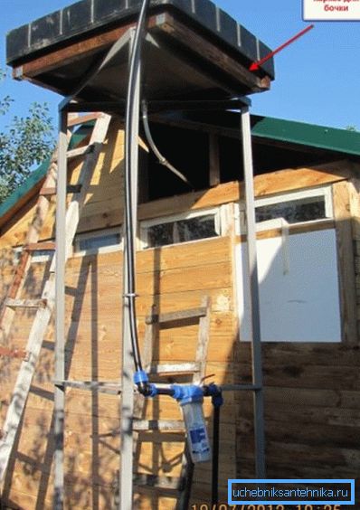 Rezervor plat pe un cadru separat. Mai jos - un furtun cu o pompă autonomă pentru alimentarea cu apă
