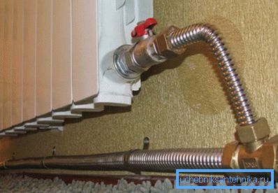 Radiatorul din fotografie este conectat printr-o conductă inoxidabilă ondulată.